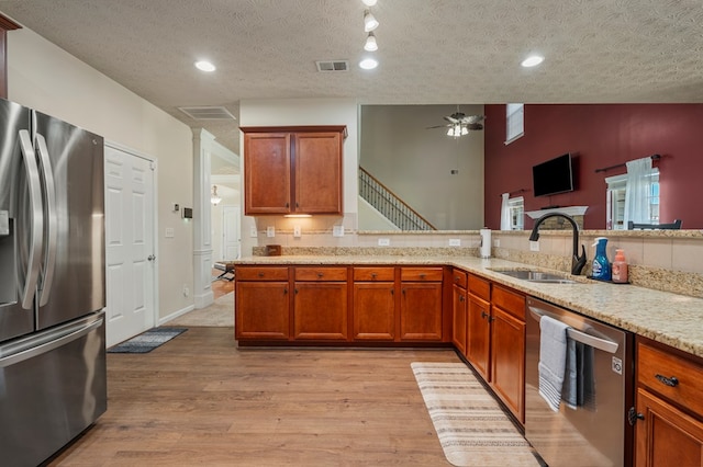 kitchen with visible vents, stainless steel appliances, light wood-style floors, and a sink