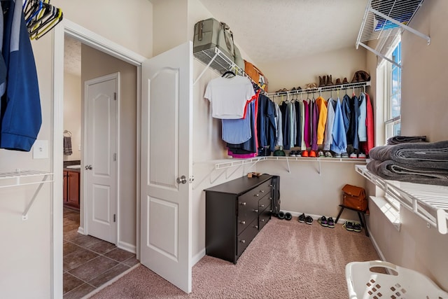 walk in closet with tile patterned flooring and carpet floors