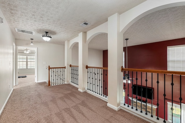 corridor with visible vents, baseboards, and carpet