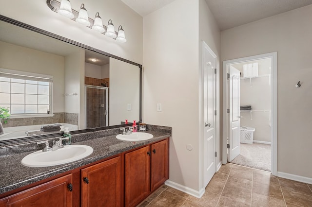 full bathroom with a sink, double vanity, a stall shower, and a spacious closet