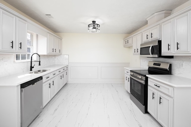 kitchen with white cabinetry, stainless steel appliances, and sink