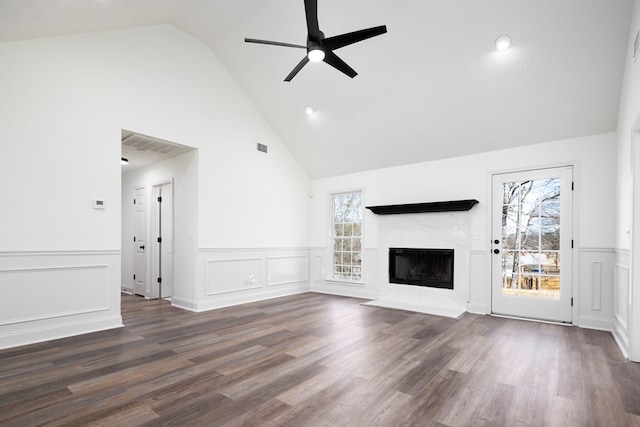 unfurnished living room with dark wood-type flooring, ceiling fan, a high end fireplace, and high vaulted ceiling