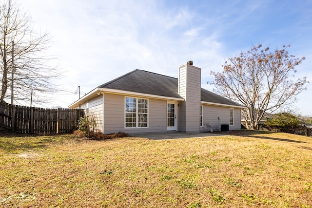 rear view of property featuring a patio area and a lawn