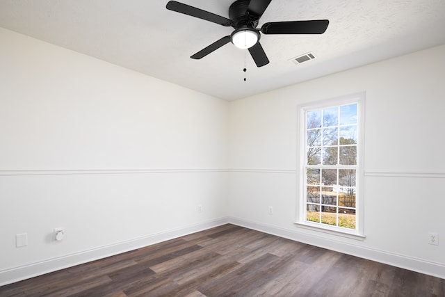 unfurnished room featuring ceiling fan, dark hardwood / wood-style floors, a textured ceiling, and a wealth of natural light