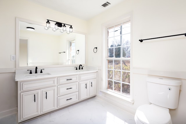 bathroom with vanity, a wealth of natural light, and toilet