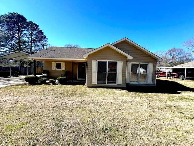 rear view of property featuring a carport and a yard