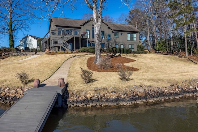 back of property with stairs and a water view