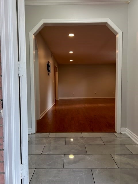 hallway featuring hardwood / wood-style floors and crown molding