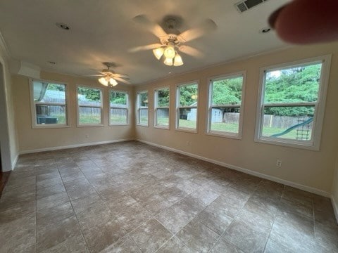 empty room featuring a wealth of natural light, ornamental molding, and ceiling fan