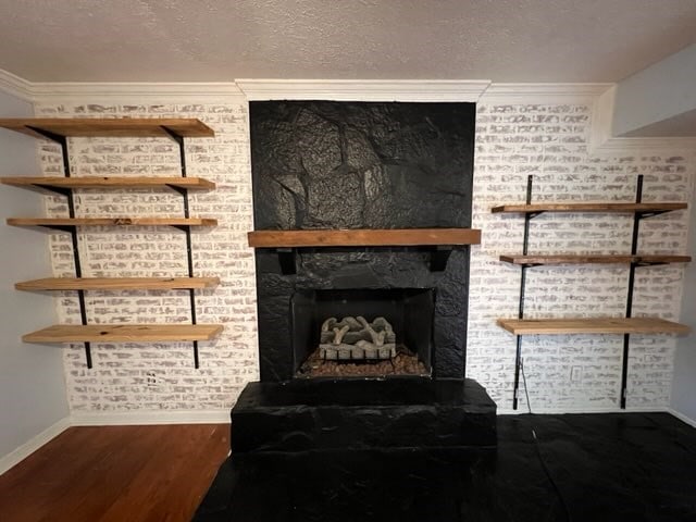 room details featuring hardwood / wood-style floors, a fireplace, crown molding, and a textured ceiling