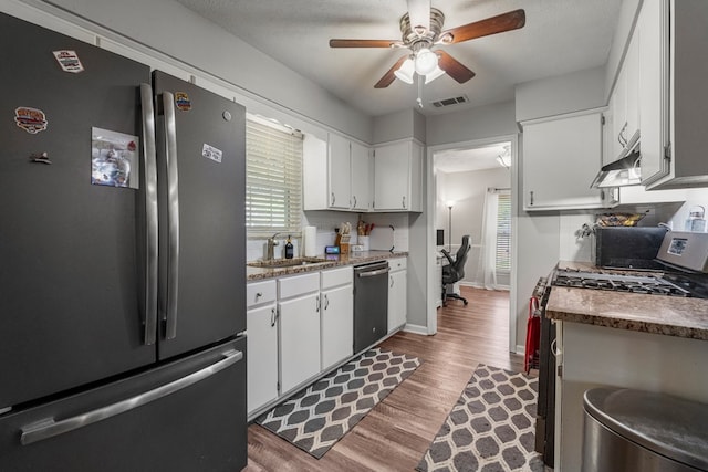 kitchen with visible vents, ceiling fan, white cabinetry, a sink, and appliances with stainless steel finishes