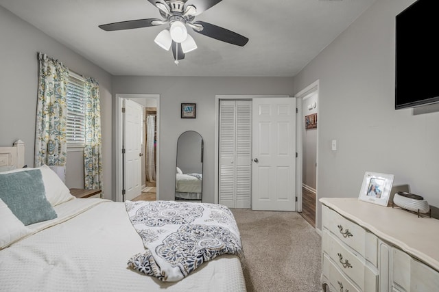 bedroom with connected bathroom, light carpet, a ceiling fan, baseboards, and a closet