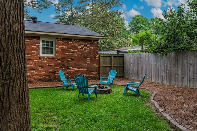 view of yard with an outdoor fire pit and fence