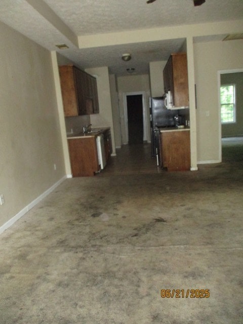 1902 6th Ct, Phenix City, AL 36867 - kitchen with open floor plan, brown cabinets, a textured ceiling, dark carpet, and ceiling fan