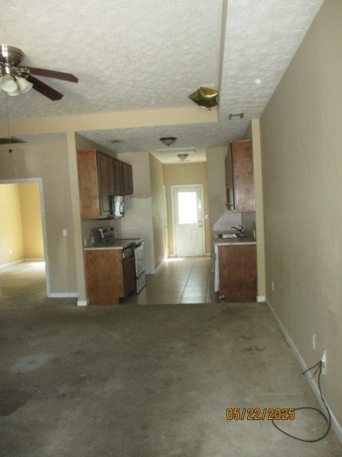 1902 6th Ct, Phenix City, AL 36867 - unfurnished living room featuring a ceiling fan, a textured ceiling, and light carpet