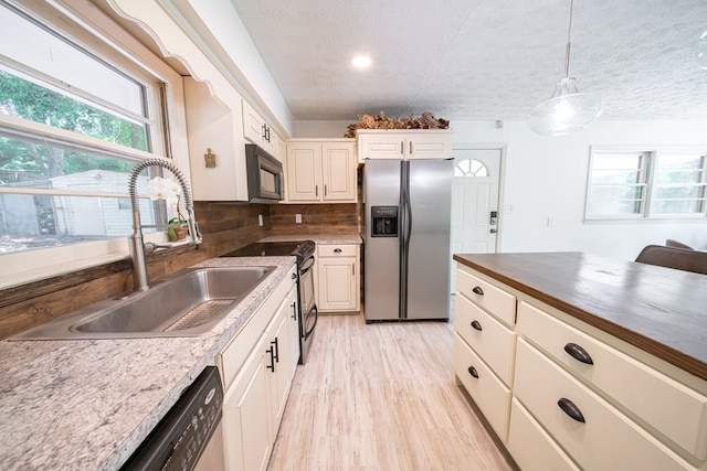 813 Crockett Dr, Columbus, GA 31904 - kitchen featuring black appliances, healthy amount of natural light, light wood-style flooring, a textured ceiling, and decorative light fixtures