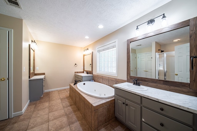 813 Crockett Dr, Columbus, GA 31904 - bathroom with a stall shower, two vanities, a tub with jets, a textured ceiling, and tile patterned floors