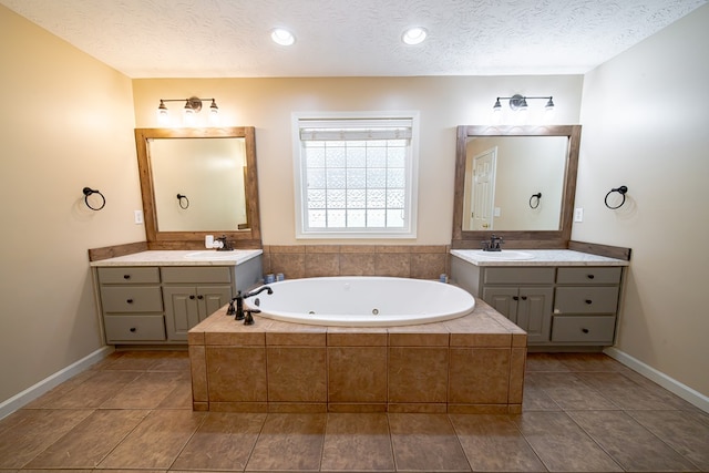813 Crockett Dr, Columbus, GA 31904 - bathroom with a jetted tub, two vanities, a textured ceiling, and tile patterned flooring