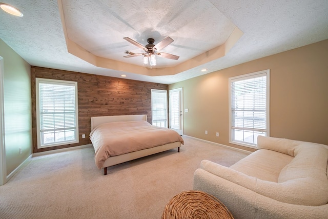 813 Crockett Dr, Columbus, GA 31904 - carpeted bedroom with a textured ceiling, multiple windows, wooden walls, a raised ceiling, and a ceiling fan