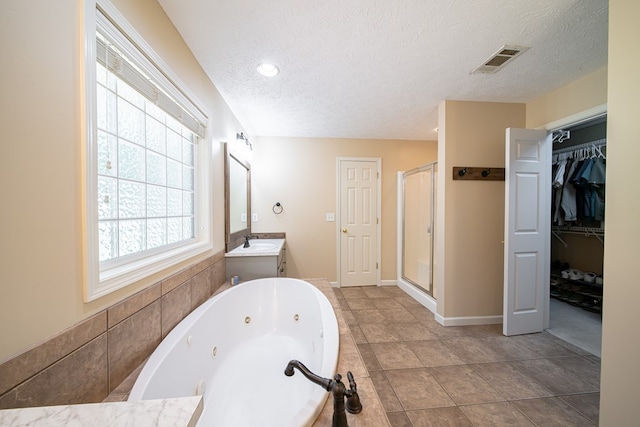 813 Crockett Dr, Columbus, GA 31904 - full bath featuring a shower stall, vanity, a tub with jets, a textured ceiling, and a walk in closet