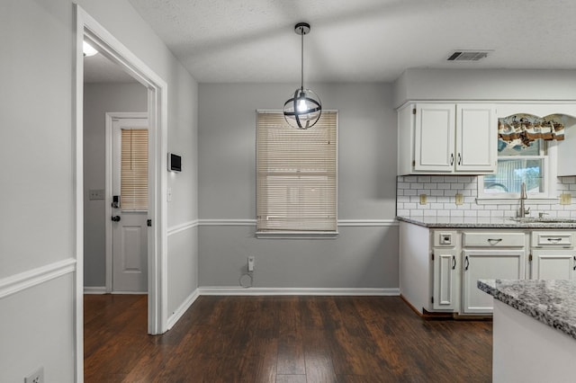 kitchen featuring dark wood finished floors, white cabinetry, and light stone counters