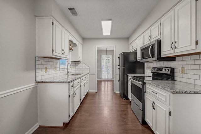 kitchen with baseboards, visible vents, appliances with stainless steel finishes, and white cabinets