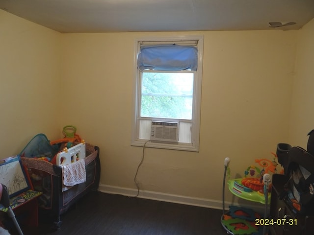 bedroom with cooling unit and dark hardwood / wood-style flooring