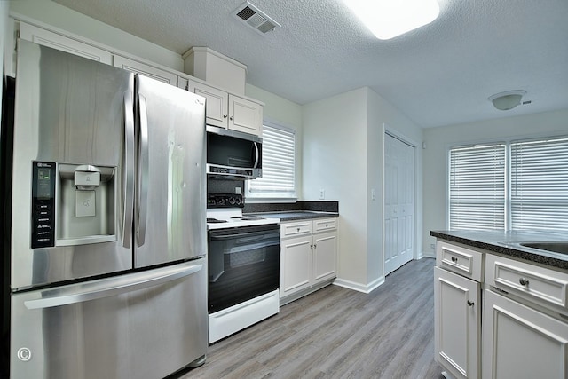 84 Summerbrook Loop, Smiths Station, AL 36870 - kitchen featuring visible vents, light wood-style floors, appliances with stainless steel finishes, and dark countertops