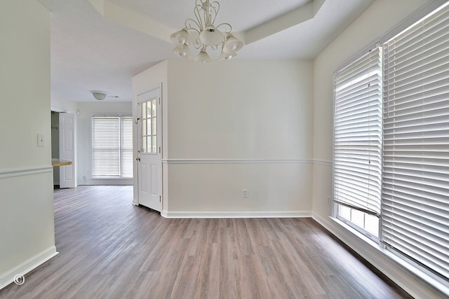 84 Summerbrook Loop, Smiths Station, AL 36870 - unfurnished dining area featuring an inviting chandelier, baseboards, and wood finished floors