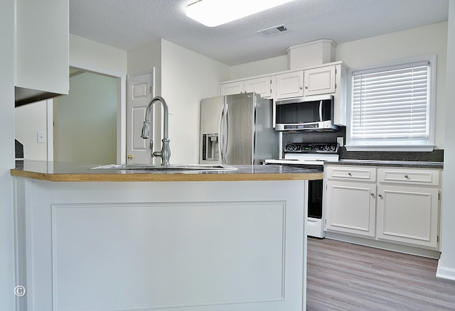 84 Summerbrook Loop, Smiths Station, AL 36870 - kitchen with visible vents, light wood-style floors, white cabinetry, a sink, and stainless steel appliances
