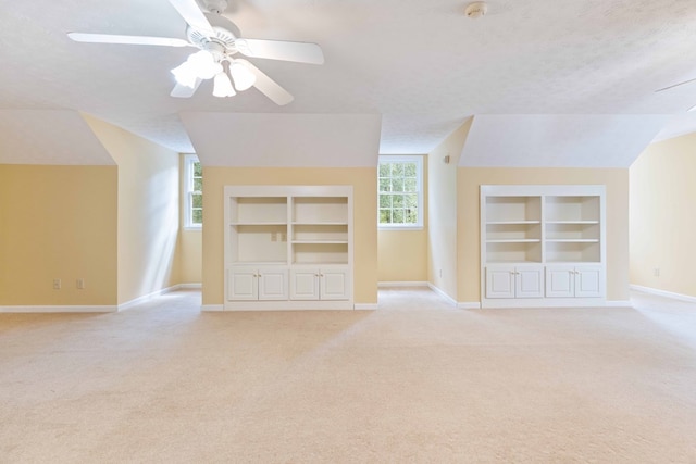 5110 Midland Trce, Columbus, GA 31820 - unfurnished living room with built in features, ceiling fan, vaulted ceiling, light carpet, and a textured ceiling