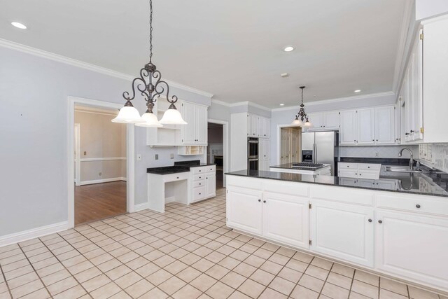 5110 Midland Trce, Columbus, GA 31820 - kitchen with stainless steel appliances, dark countertops, white cabinetry, a chandelier, and crown molding