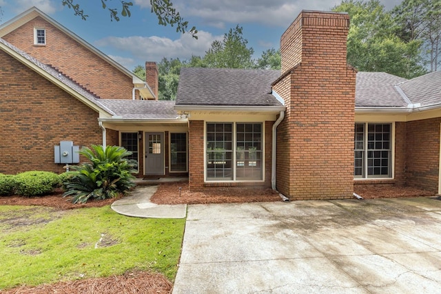 5110 Midland Trce, Columbus, GA 31820 - rear view of house featuring a chimney, brick siding, a shingled roof, and a lawn