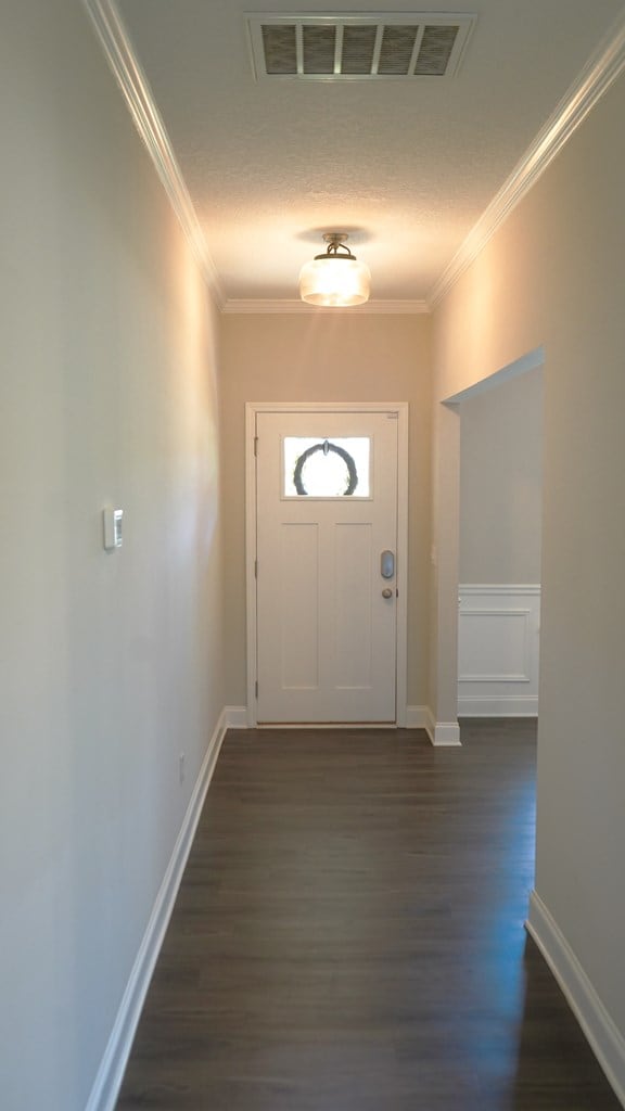 8840 Sullivans Dr, Midland, GA 31820 - entryway featuring dark wood-style floors, crown molding, baseboards, and a textured ceiling