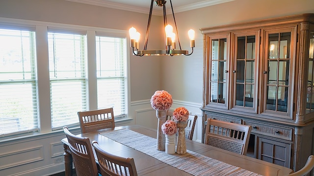 8840 Sullivans Dr, Midland, GA 31820 - dining space featuring a chandelier, a decorative wall, ornamental molding, and wainscoting