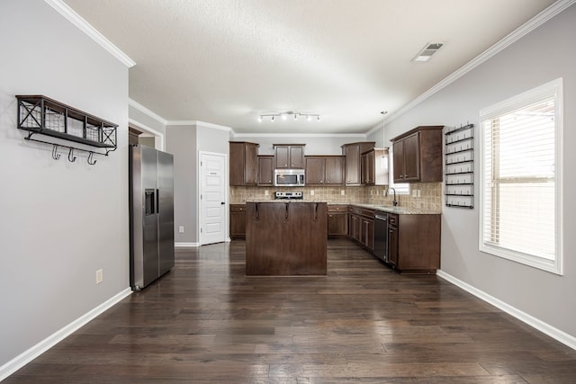 kitchen with a center island, appliances with stainless steel finishes, sink, and dark brown cabinets