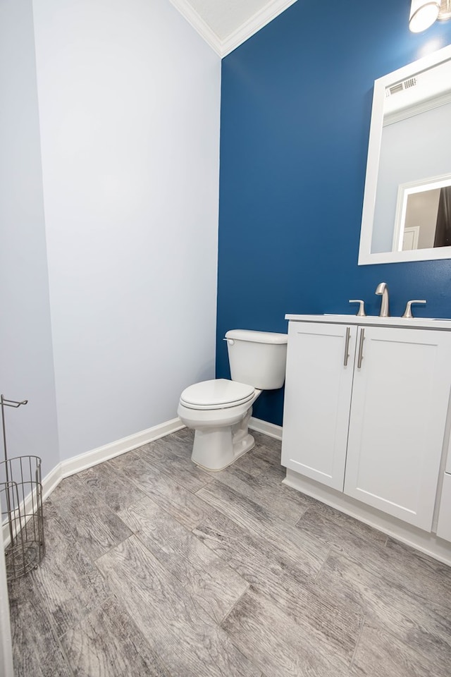 bathroom with vanity, crown molding, toilet, and hardwood / wood-style flooring