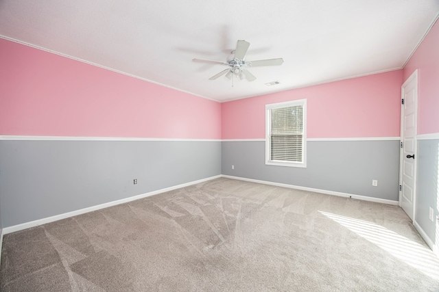 carpeted spare room with crown molding and ceiling fan