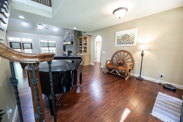 3450 Mckee Rd, Upatoi, GA 31829 - living area featuring arched walkways, a fireplace, a ceiling fan, baseboards, and dark wood finished floors