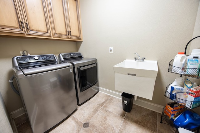 3450 Mckee Rd, Upatoi, GA 31829 - laundry area with washer and dryer, cabinet space, baseboards, and light tile patterned flooring