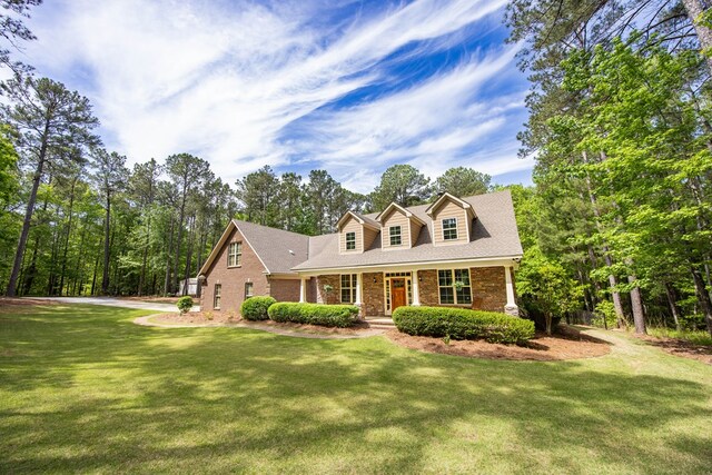 3450 Mckee Rd, Upatoi, GA 31829 - new england style home with a front yard, covered porch, and brick siding