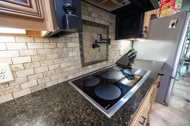 3450 Mckee Rd, Upatoi, GA 31829 - kitchen with black electric stovetop, tasteful backsplash, freestanding refrigerator, and dark stone counters