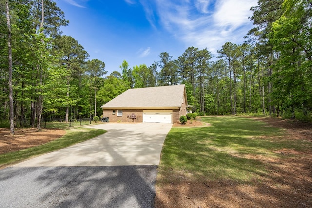 3450 Mckee Rd, Upatoi, GA 31829 - view of side of home featuring concrete driveway, a lawn, a garage, and a forest view