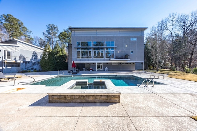 back of house with a patio area and a swimming pool with hot tub