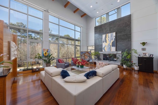 living room with beam ceiling, a towering ceiling, and dark hardwood / wood-style floors