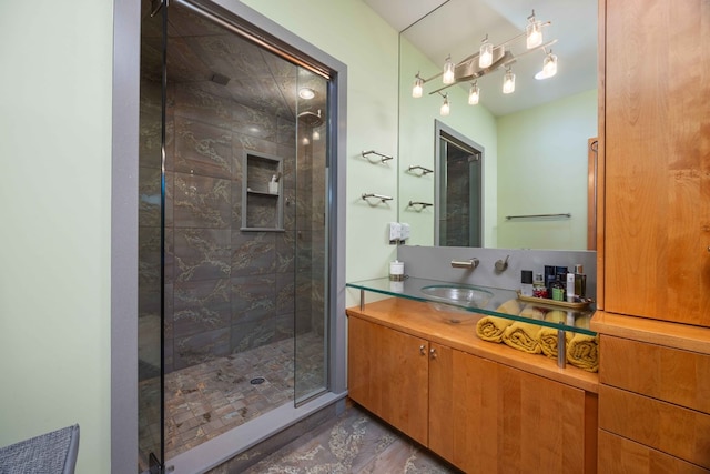 bathroom with tiled shower and vanity