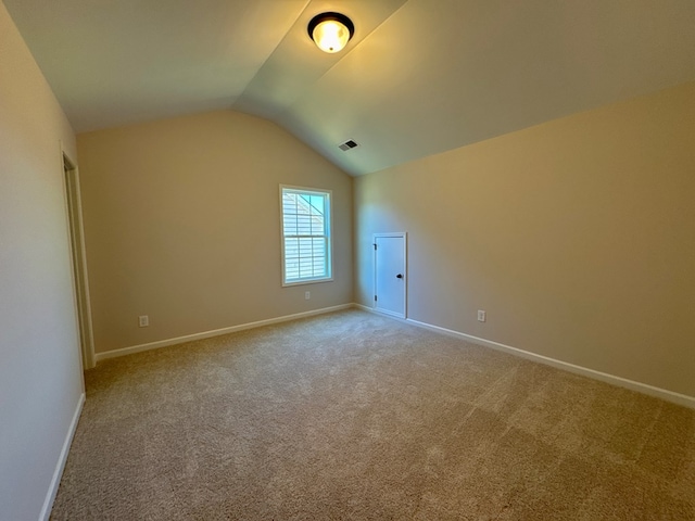 additional living space with light colored carpet and lofted ceiling