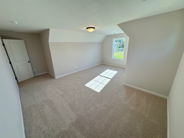 bonus room featuring light carpet and vaulted ceiling