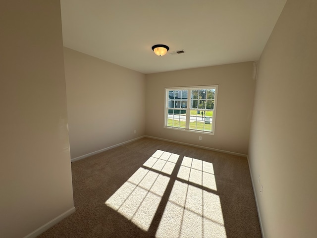 spare room featuring dark carpet