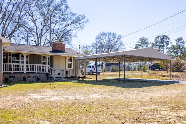 view of front facade with dirt driveway, a chimney, covered porch, board and batten siding, and a front yard